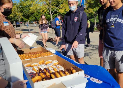 Students at Wescoe Beach receiving donuts from SUA between classes