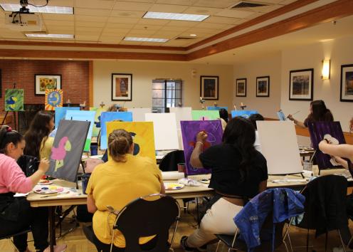 Participants draw their Jayhawks on the canvases