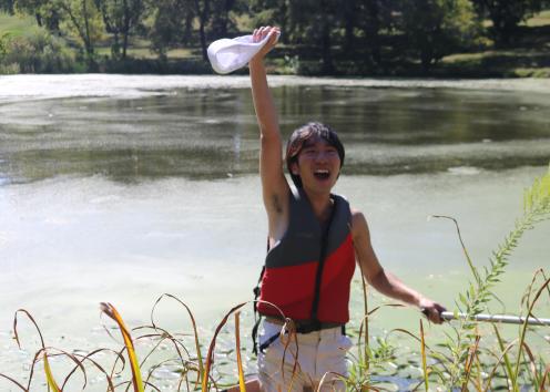 SUA Sailor celebrates successfully crossing Potter Lake in their cardboard boat
