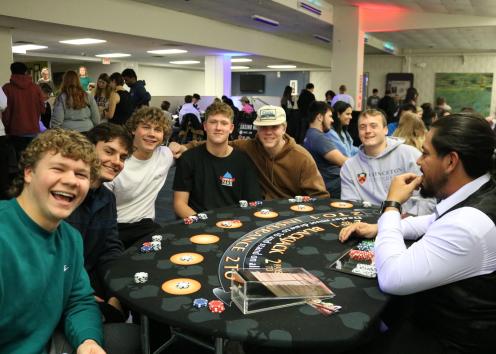 Participants pose for a photo at a Black Jack table
