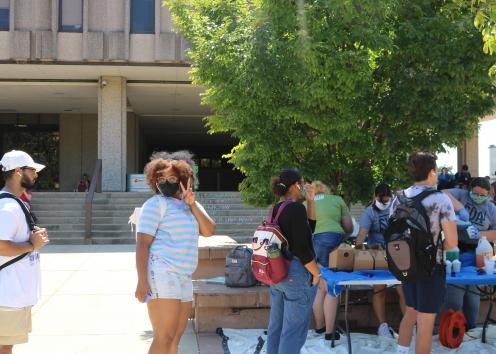 Students lining up to receive shaved ice cups in front of Wescoe Hall
