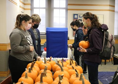 Students choosing pumpkins and paints at the event