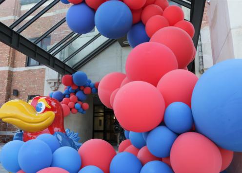 Jayhawk in front of the Kansas Union and crimson and blue balloons